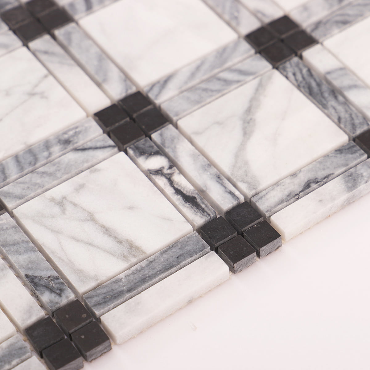 Close-up showing marble veining, gray border strips, and raised black dot corner pieces.