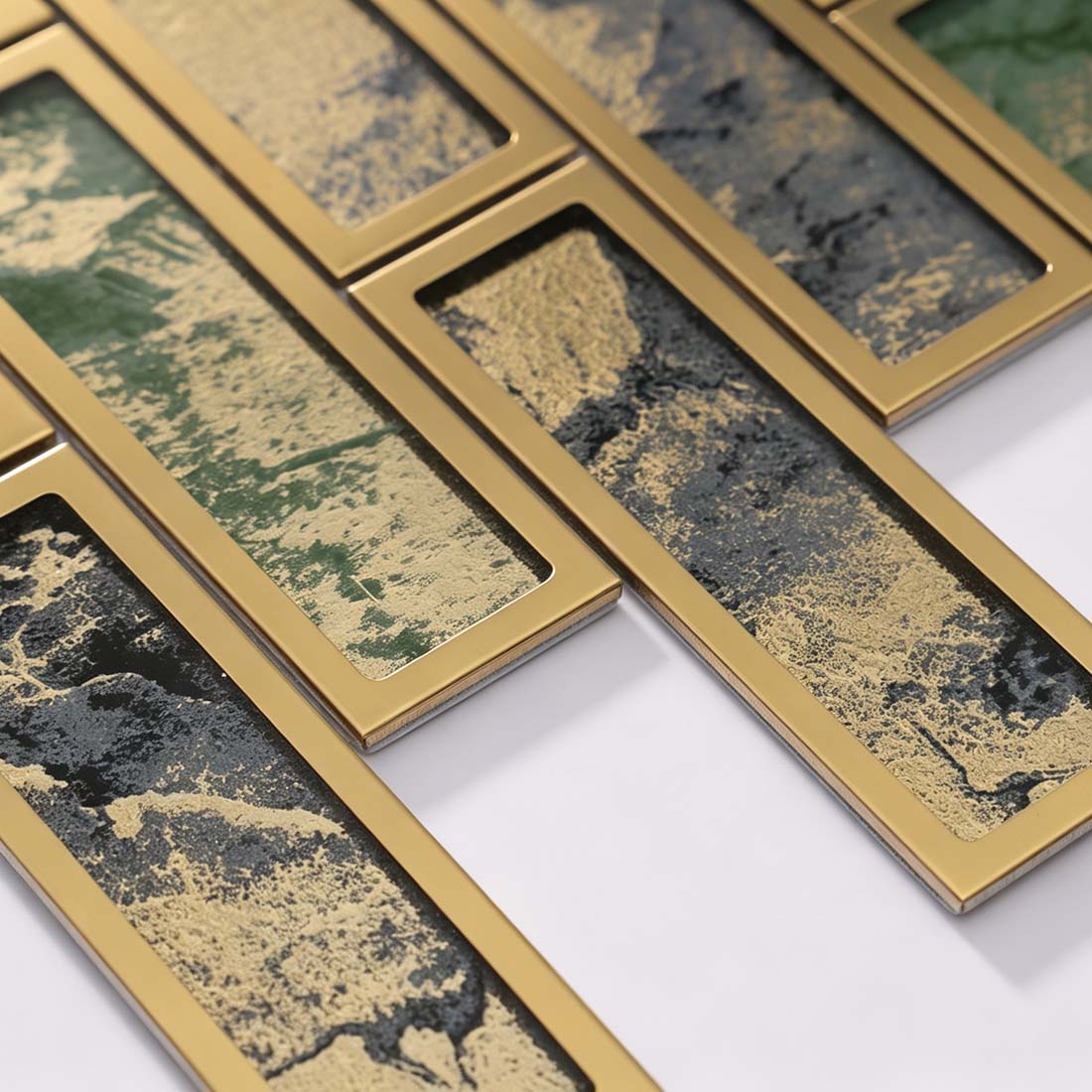 Angled close-up of textured green and black rectangular mosaic tiles with gold frames