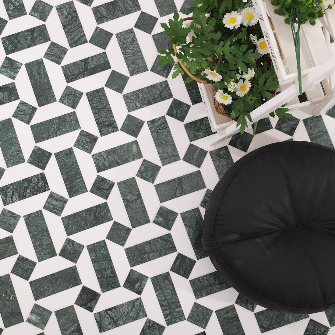 Top view of installed green and white geometric marble mosaic with pouf and floral decor