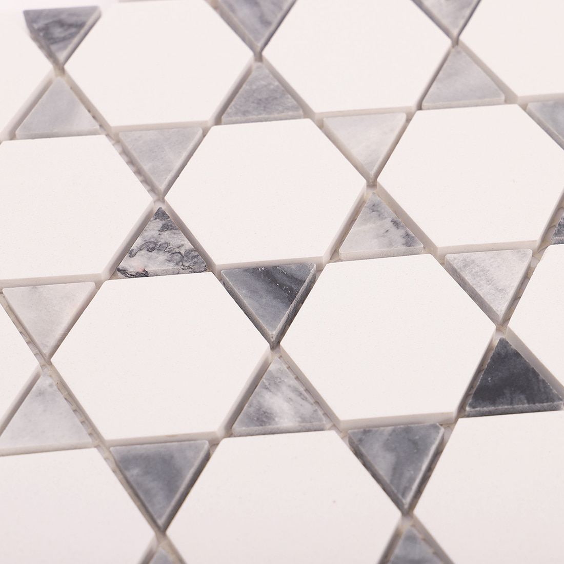 Close up of triangle accent insert between white hexagon marble pieces