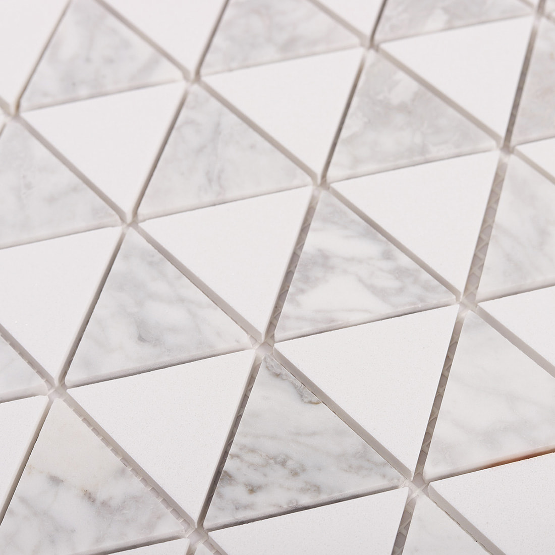 Close up of triangle marble and white mosaic pattern with grout lines