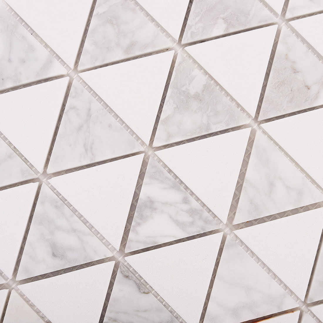 Detailed close up of triangle mosaic tile surface in marble and white