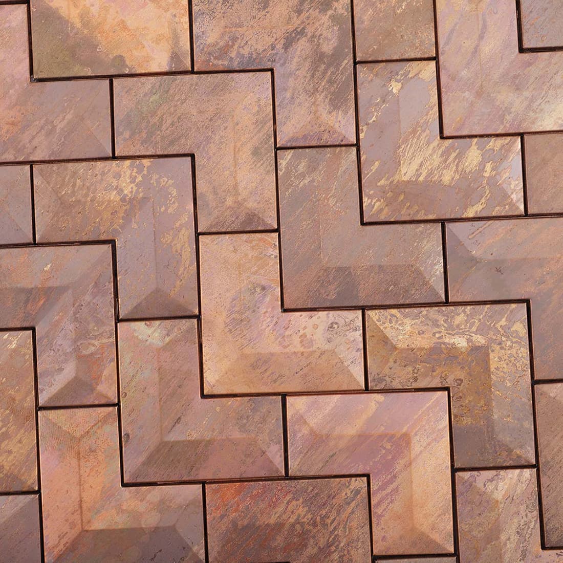 Detailed view of the weathered and rusted texture on bronze chevron metal tiles.