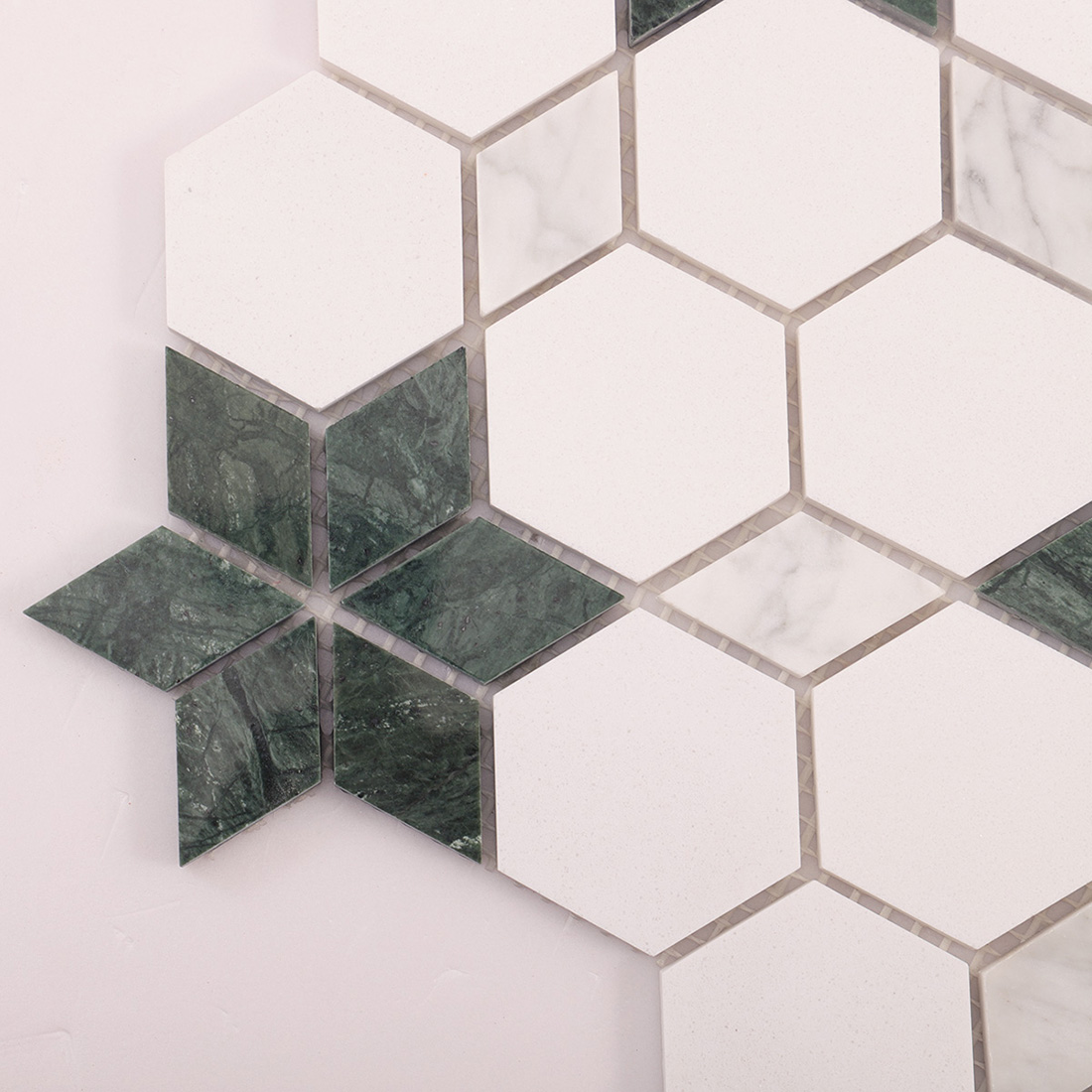 Close-up of white hexagon mosaic pattern featuring green star inlay accents.
