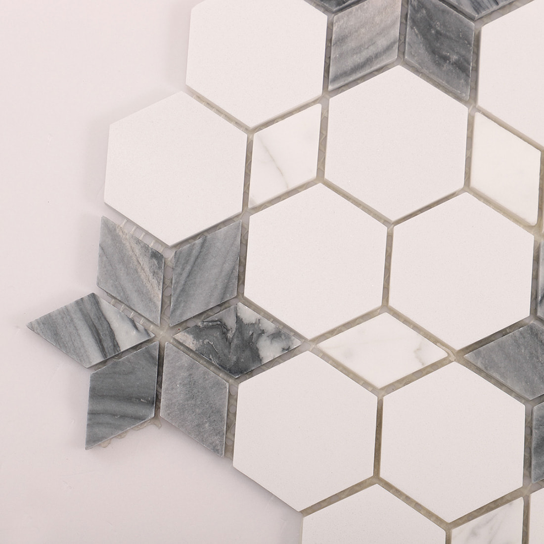 Angled corner view of white hexagon mosaic with grey star inlay detail.