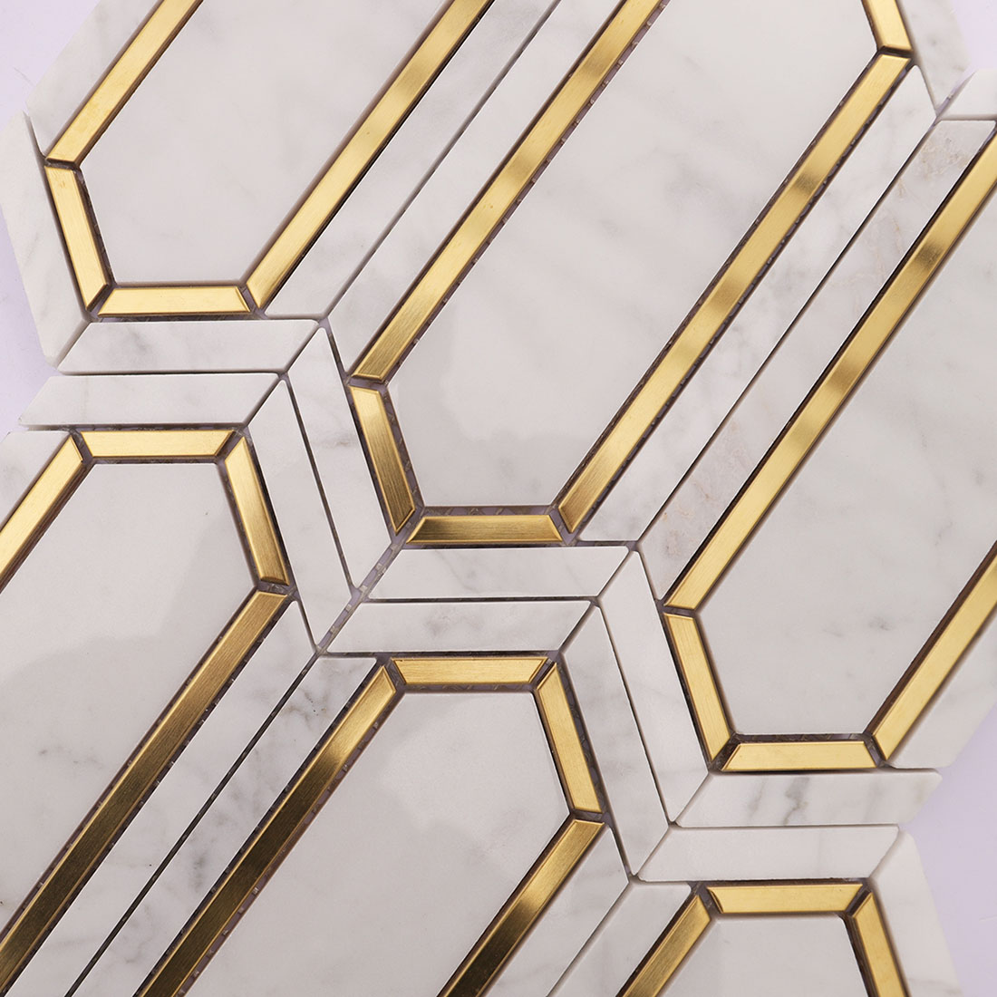 Close-up of white gold elongated hexagon marble mosaic tile with gold accents
