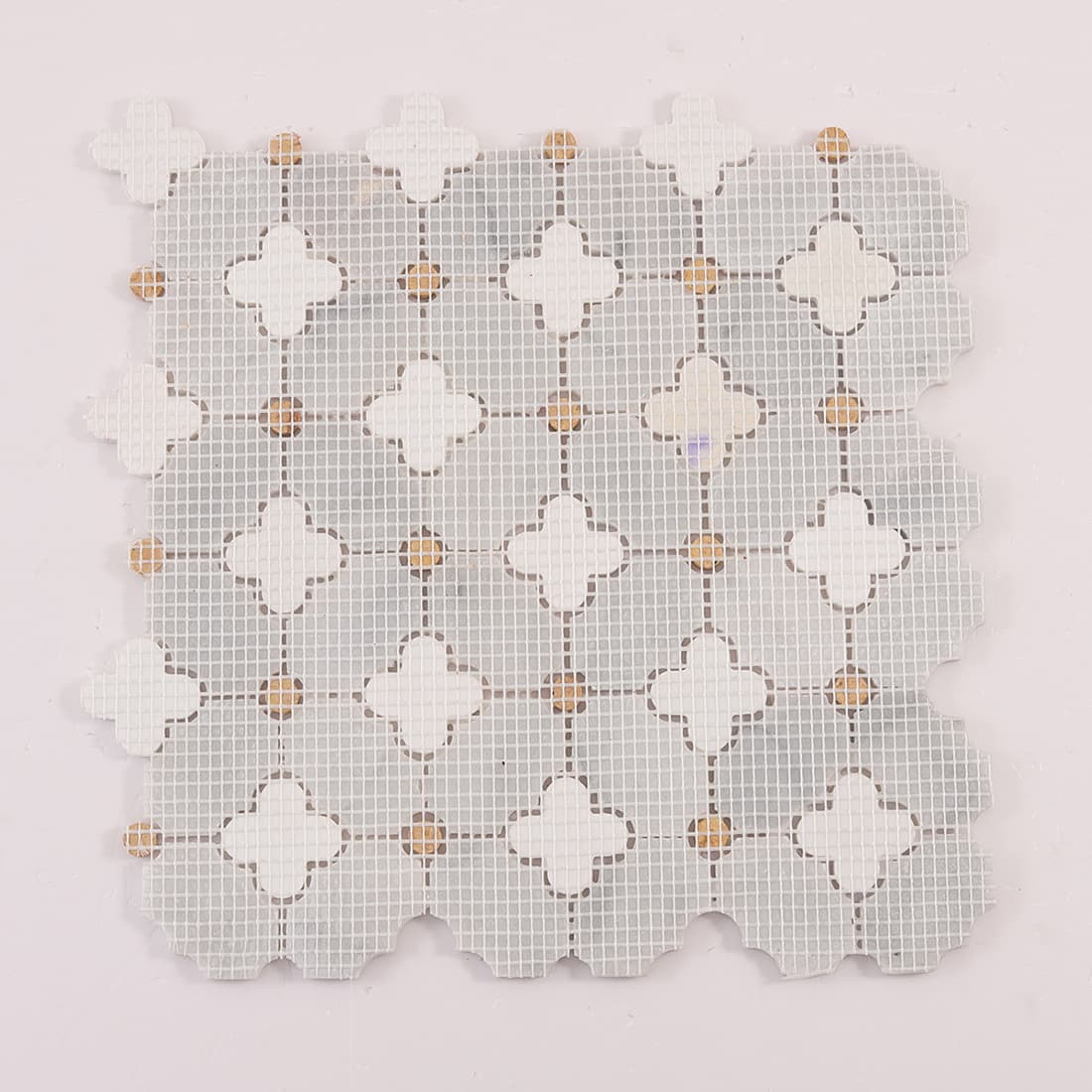 Angled view showing mosaic thickness, edge profile, and raised clover inserts