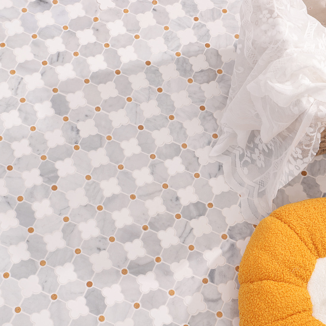 Top view of installed clover mosaic with lace cloth and orange cushion decor