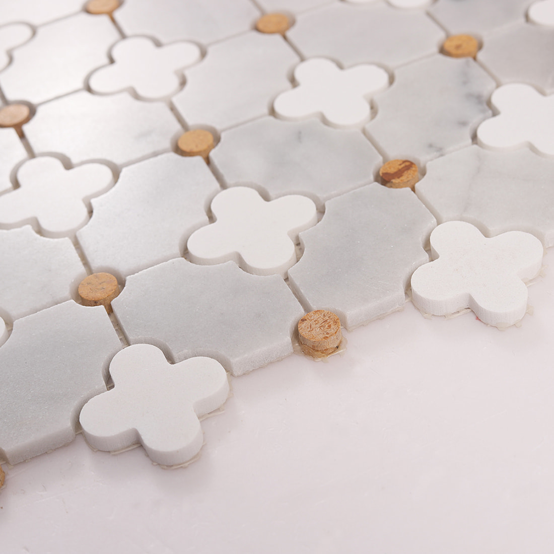 Macro view of clover insets and gray marble pieces with visible grout lines