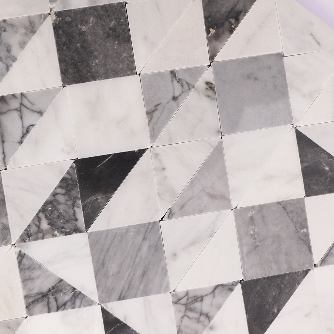 Close-up of white gray geometric marble mosaic tile with contrasting stone veining