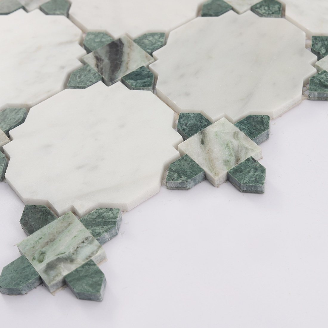 Angled view showing texture and pattern of white marble mosaic with green corners