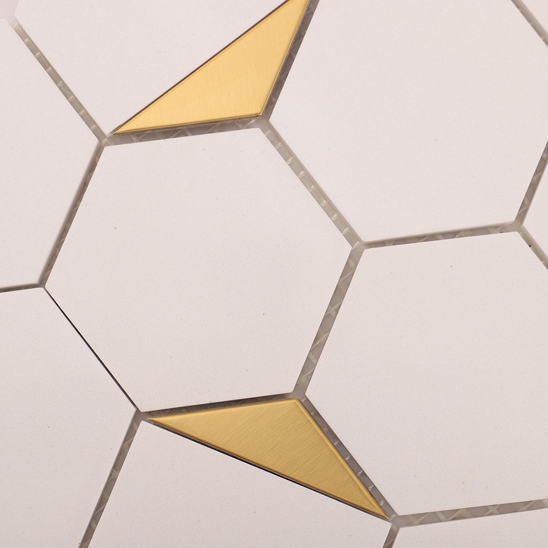 Angled close-up showing gold triangle accent and grout lines
