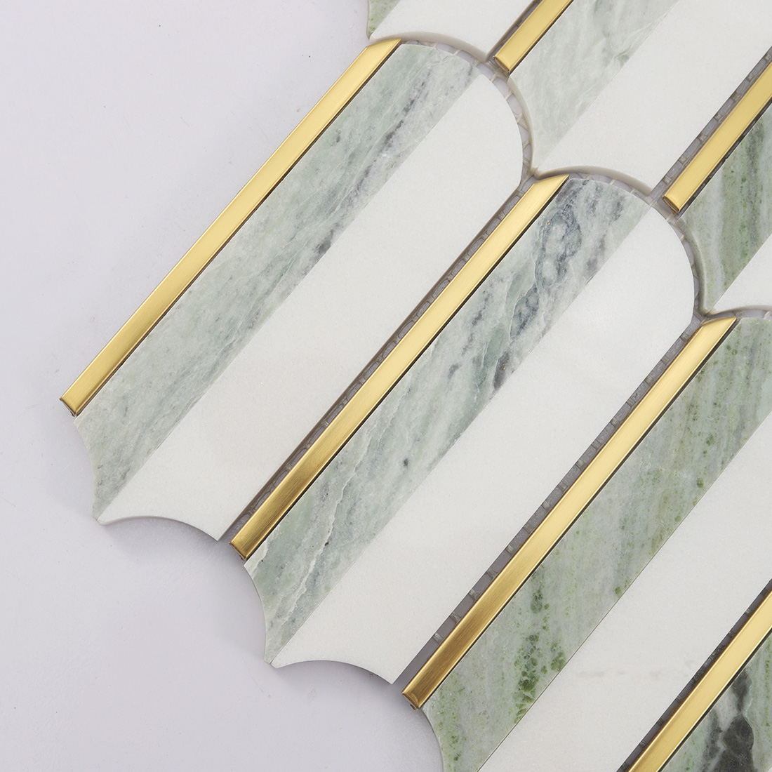 Close-up of white light green marble mosaic with brushed gold trim