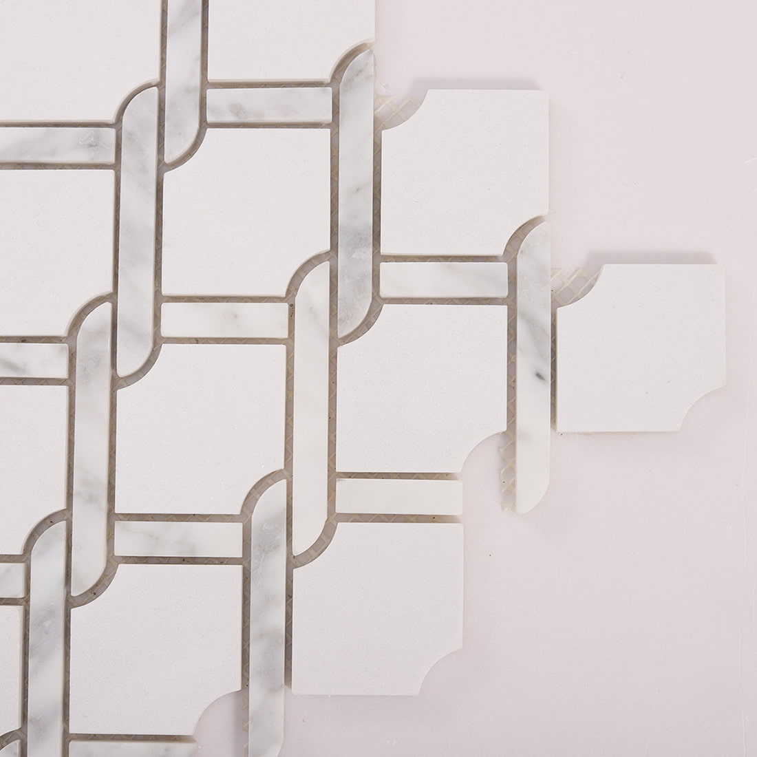Close up of white marble chain link mosaic tile corner detail