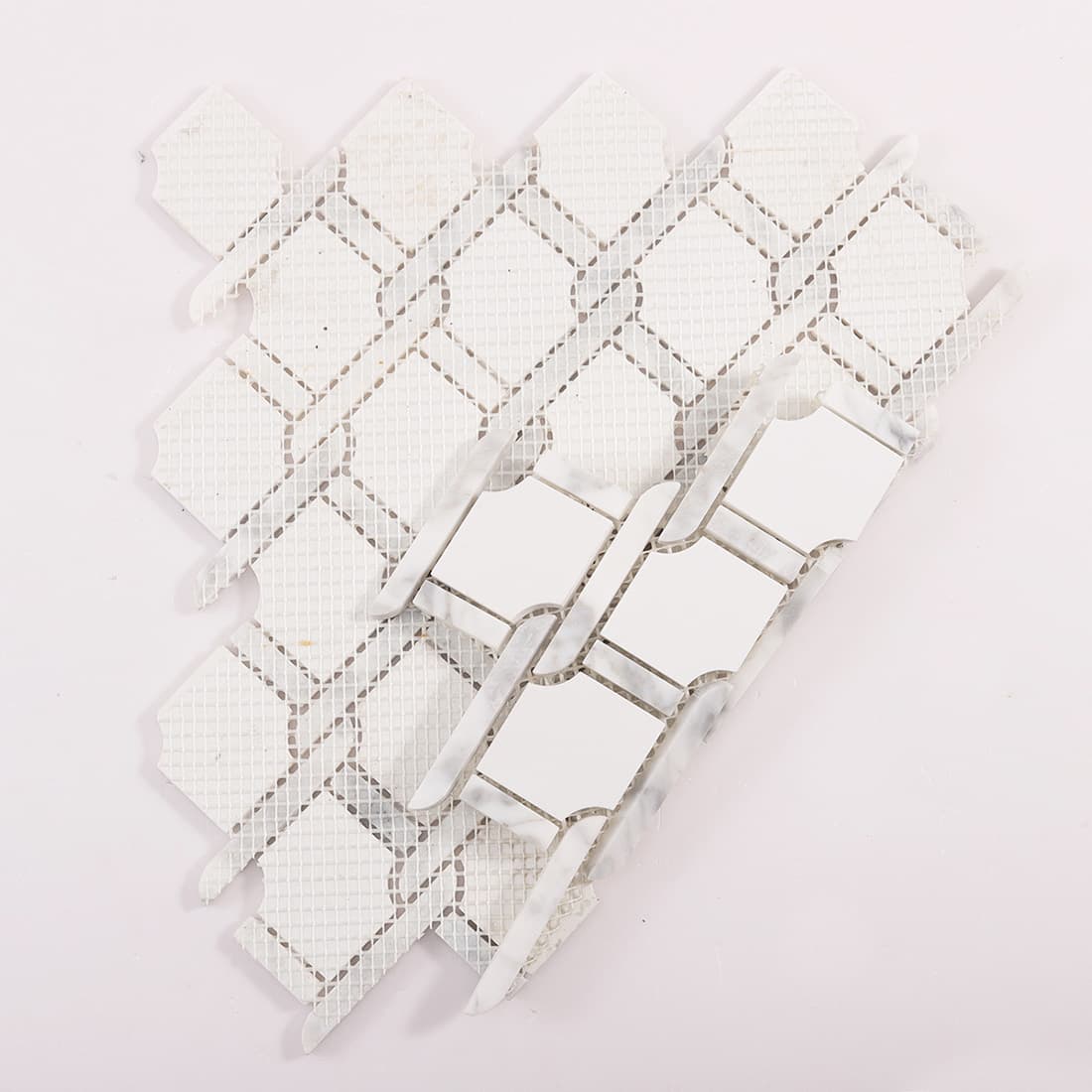 Back view of white marble chain link mosaic tile sheet with mesh backing