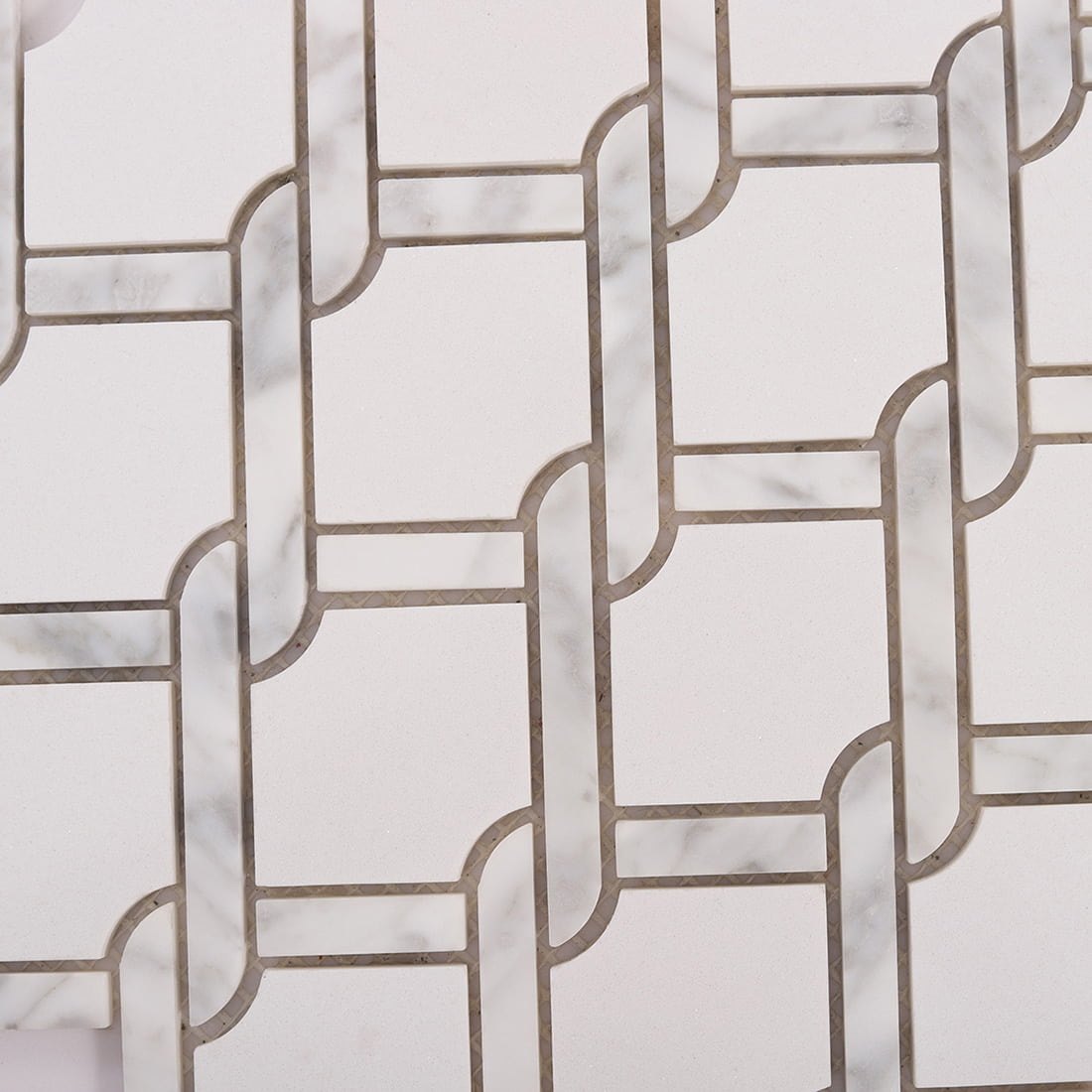 Detailed view of white marble chain link mosaic texture and grout lines