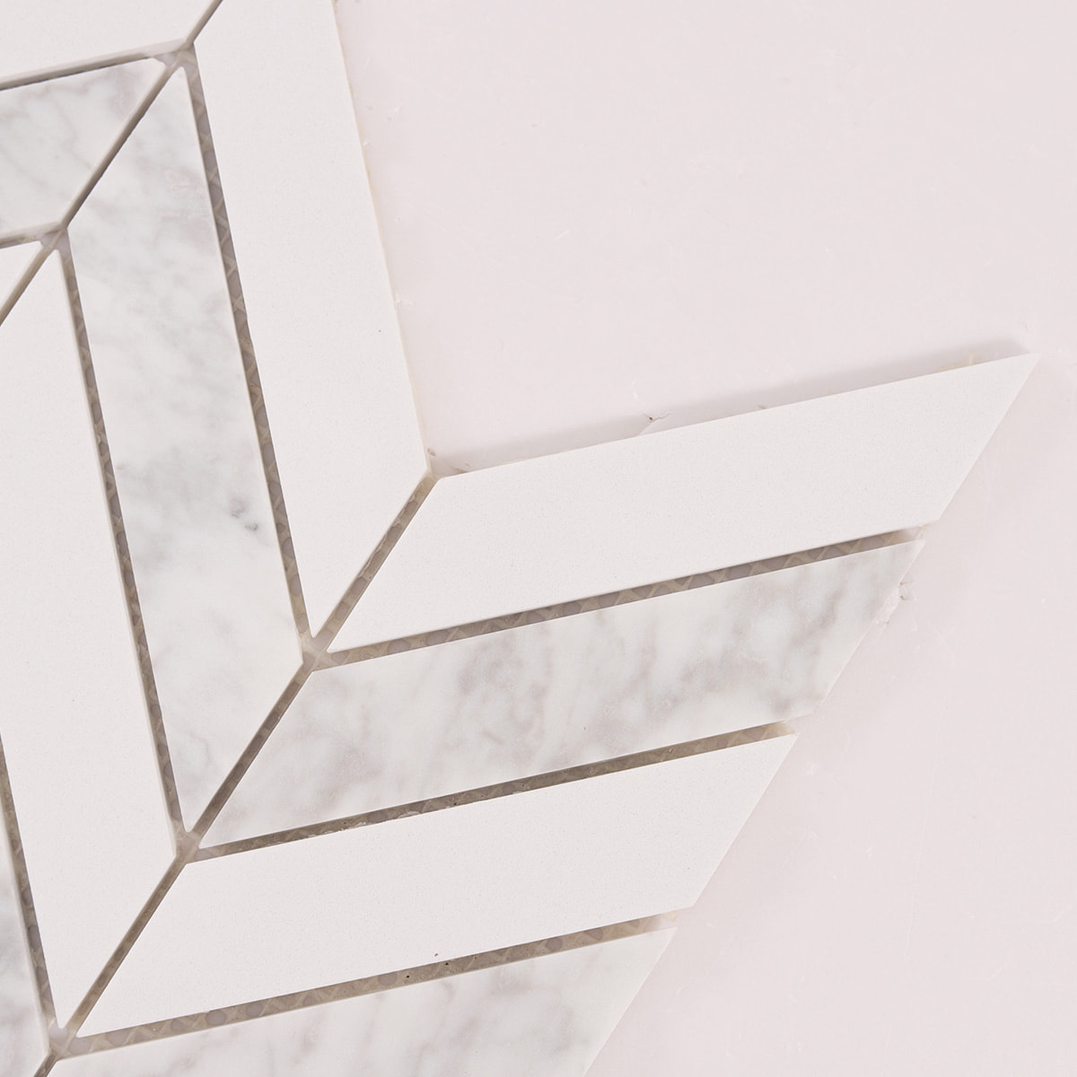 Close up of chevron mosaic corner showing grout joints and stone edges