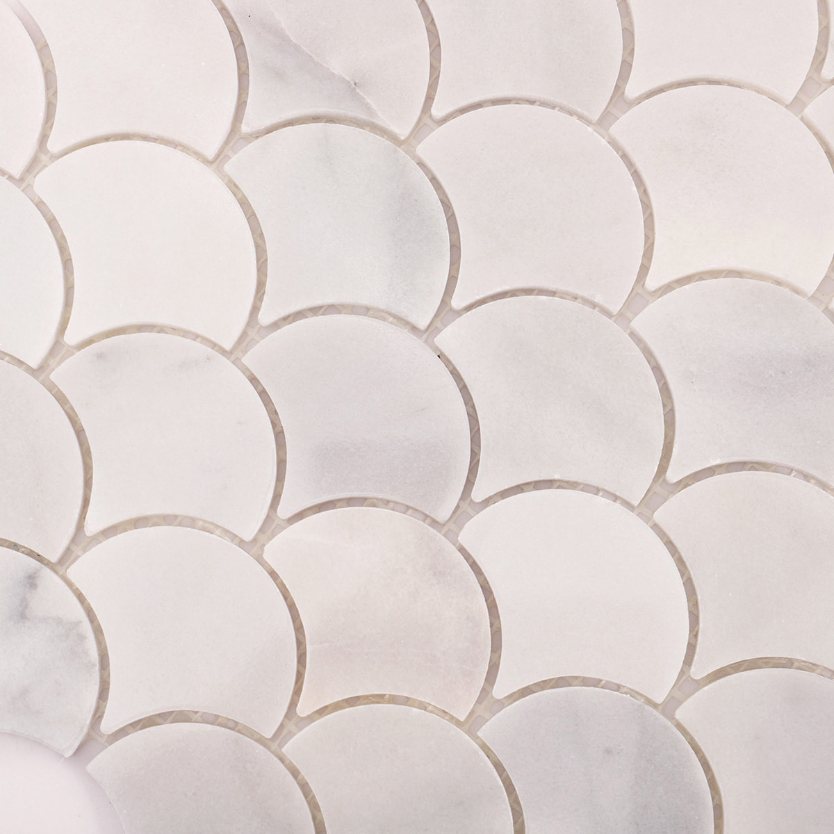 Close up of white marble fan scallop pattern showing smooth surface and light veining
