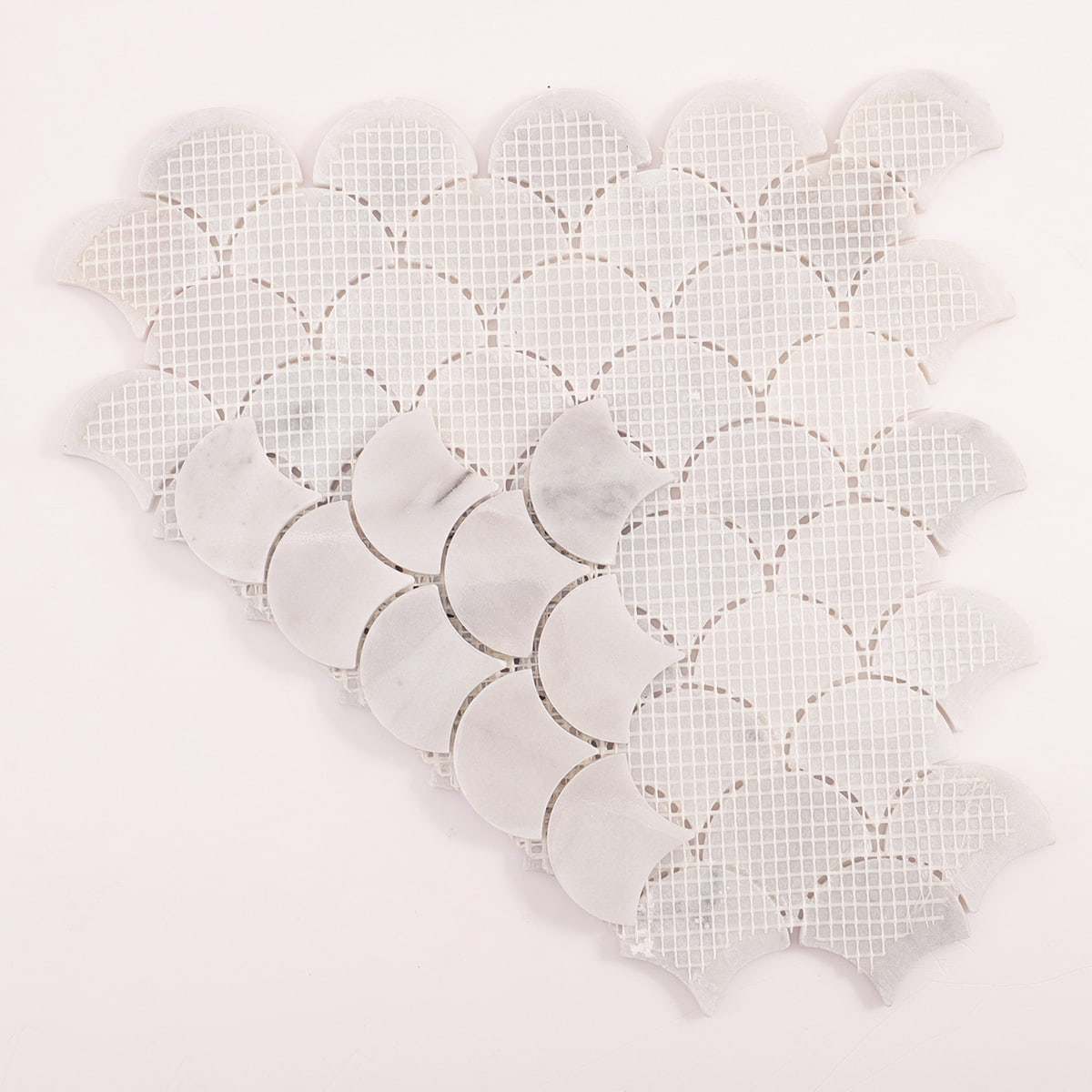 Back view of white marble fan scallop mosaic sheet showing mesh backing and layout