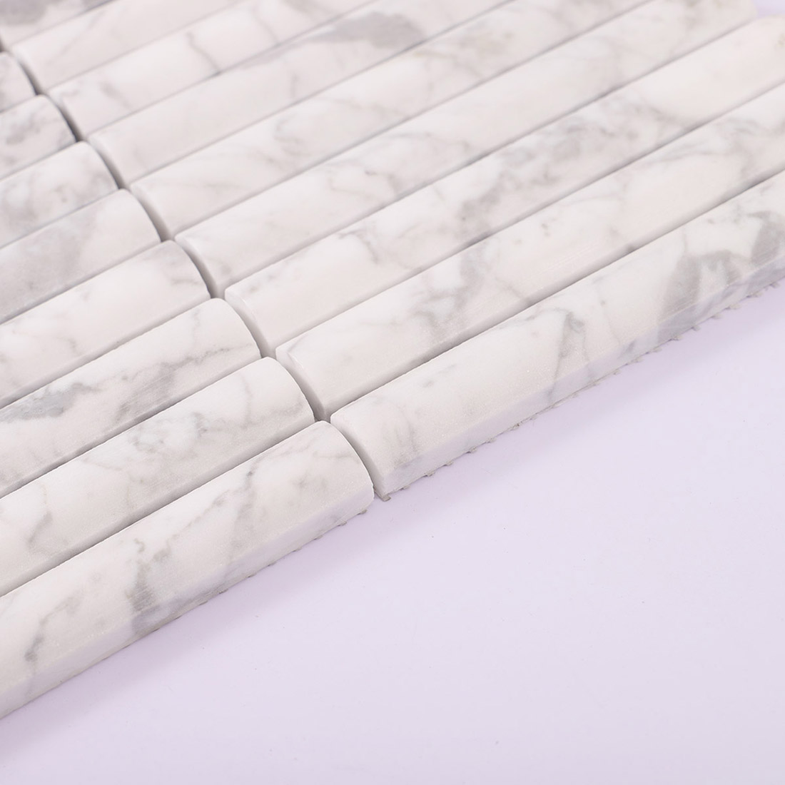 White marble half round tile showing thickness and a raised rounded profile