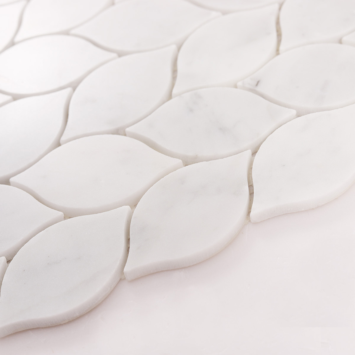 Angled close up of white marble leaf mosaic tiles highlighting thickness