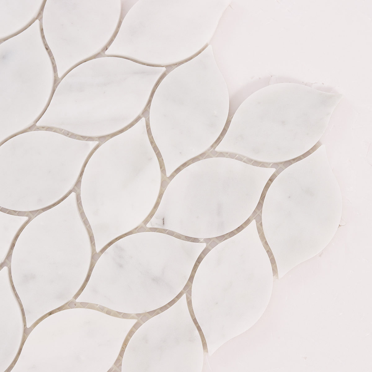 Close up of white marble leaf mosaic tiles showing edges and joints