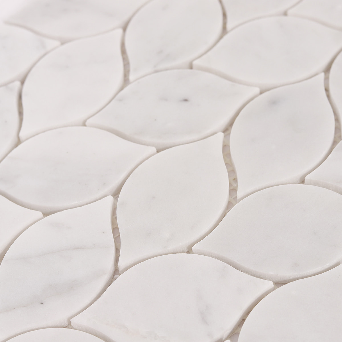 Detailed view of white marble leaf mosaic tile surface and grout lines