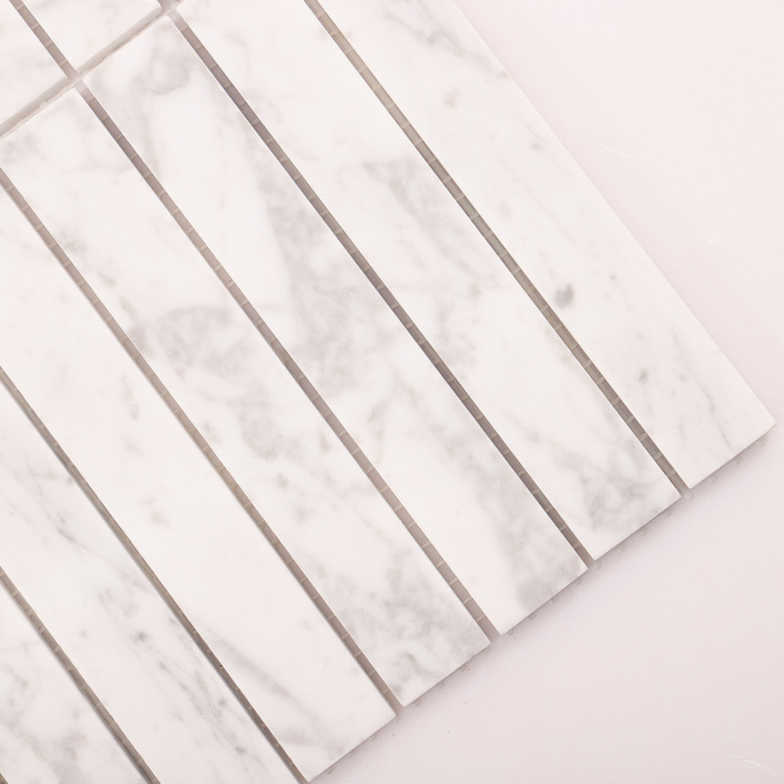 Diagonal corner close-up of white marble linear mosaic tile sheet