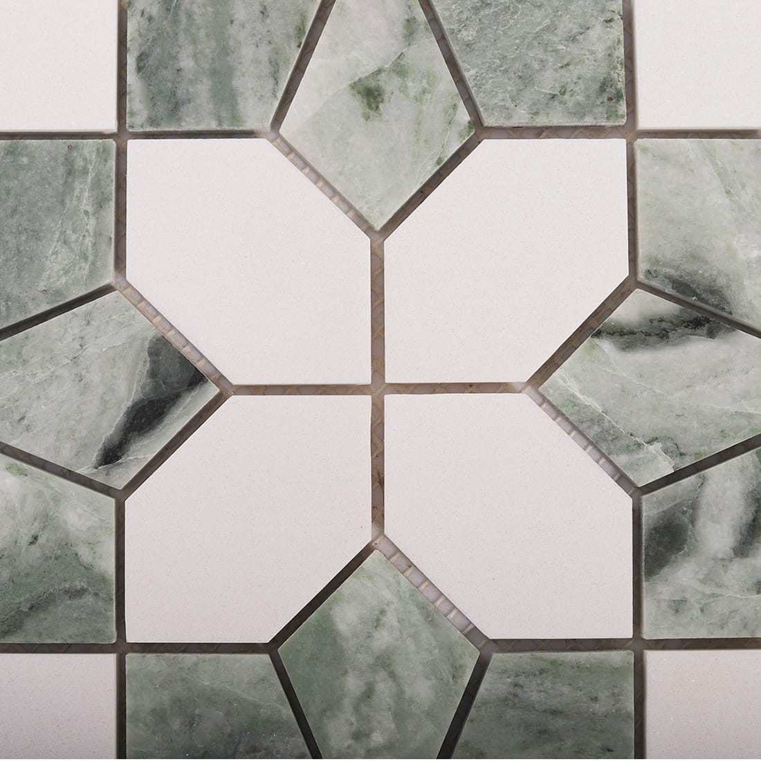 Close up of white octagon tiles with green marble diamond accents and grout lines
