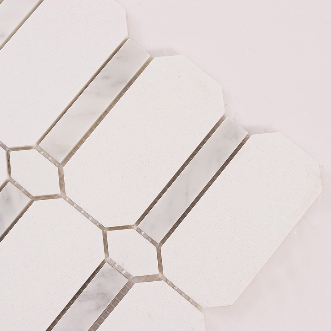 Close up of white octagon mosaic tiles with marble strip and joints