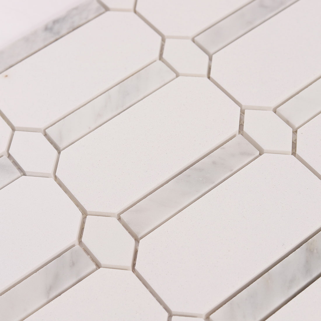 Angled close up of white octagon mosaic tile surface and marble inlays
