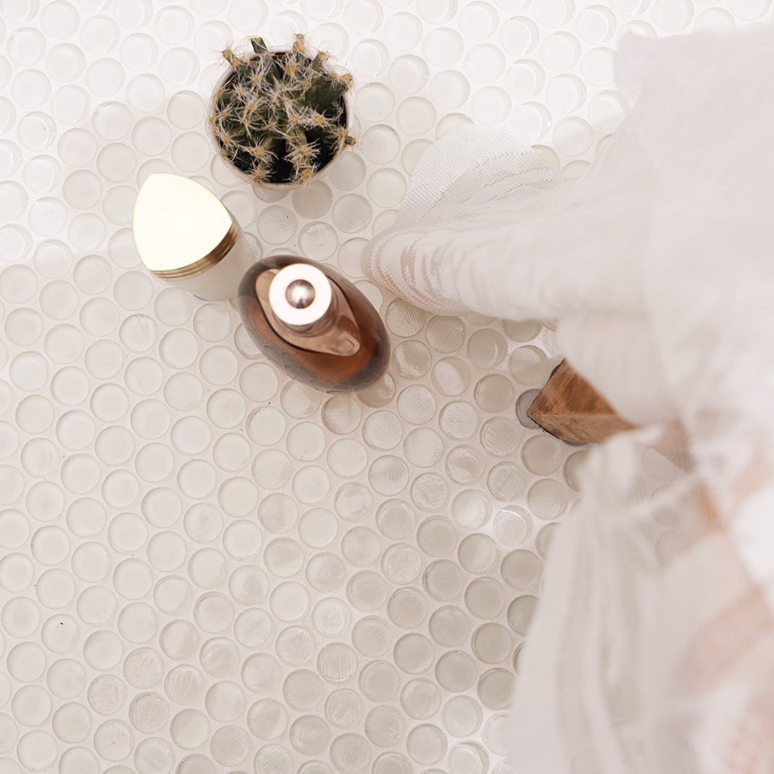 Overhead view of polished white glass mosaic tiles applied on a floor with decor.