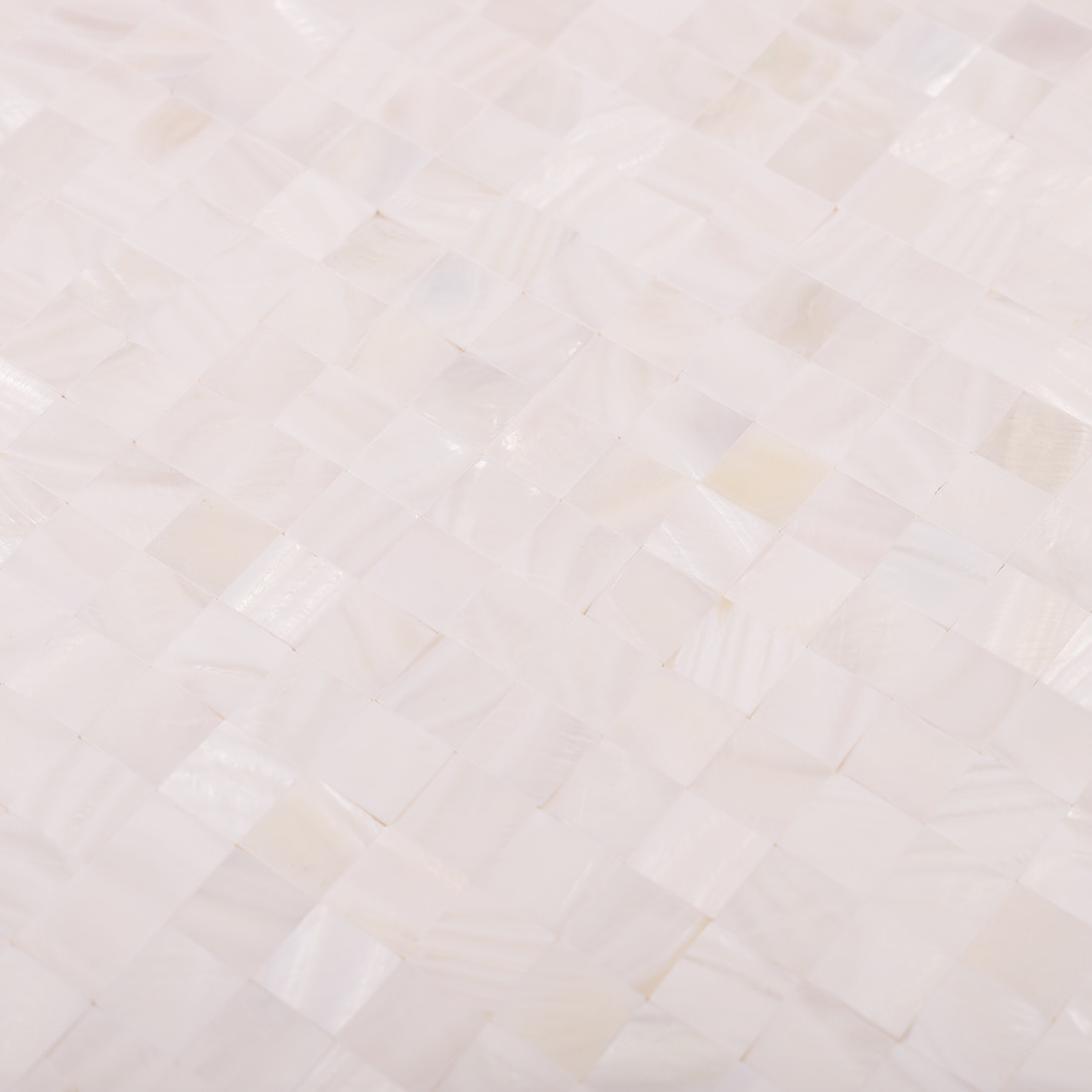 Close-up of white shell mosaic tiles showing glossy square chip texture