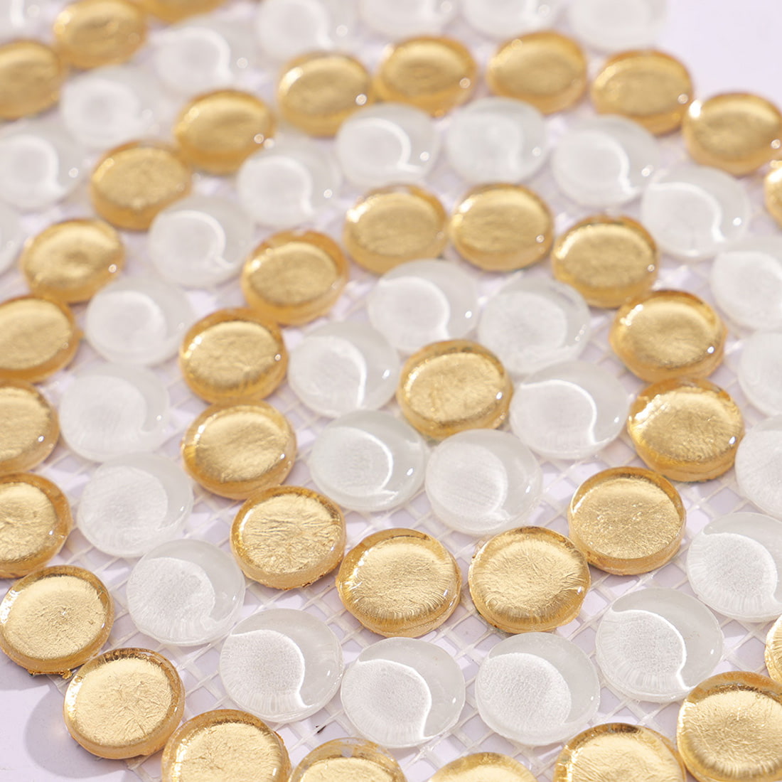 Close-up view of white and gold round glass mosaic surface and pattern