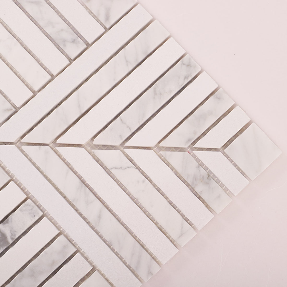 Close up of white marble chevron strips and grout joints