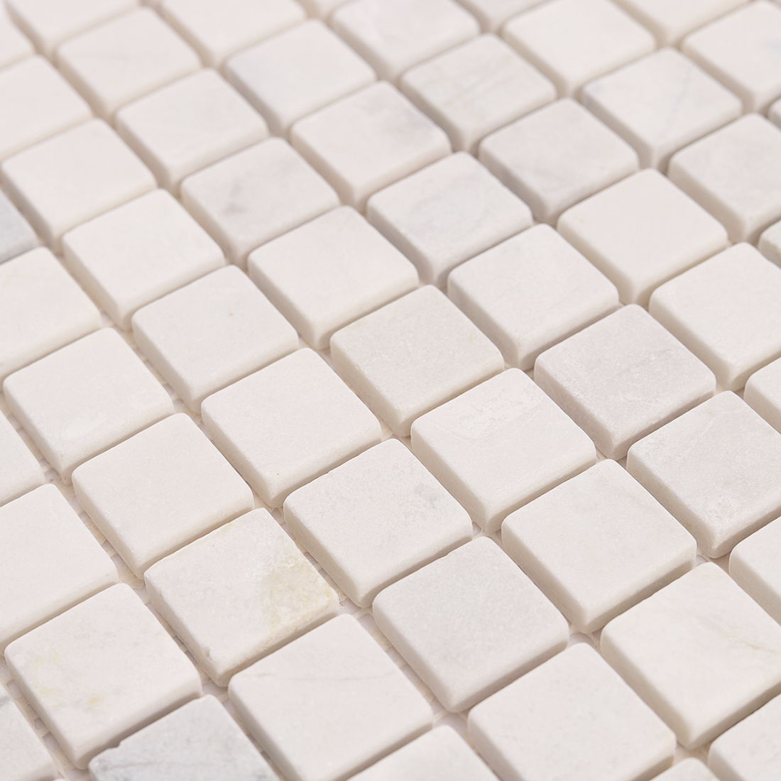 Close detail of honed white marble square mosaic tile surface texture