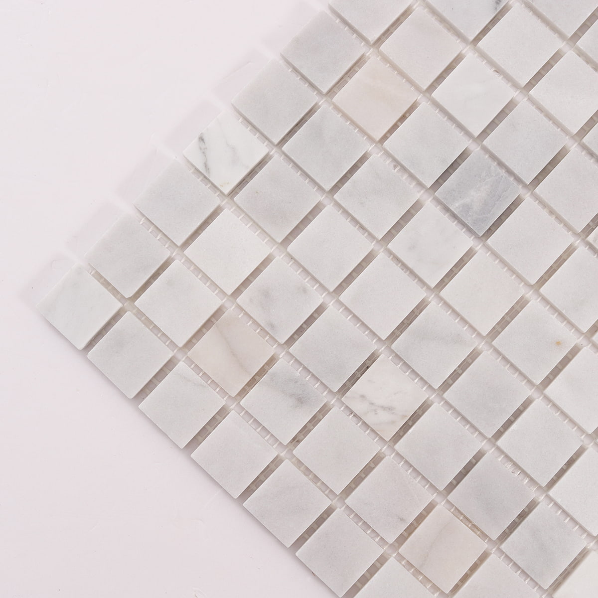 Diagonal corner detail of white marble square mosaic tiles