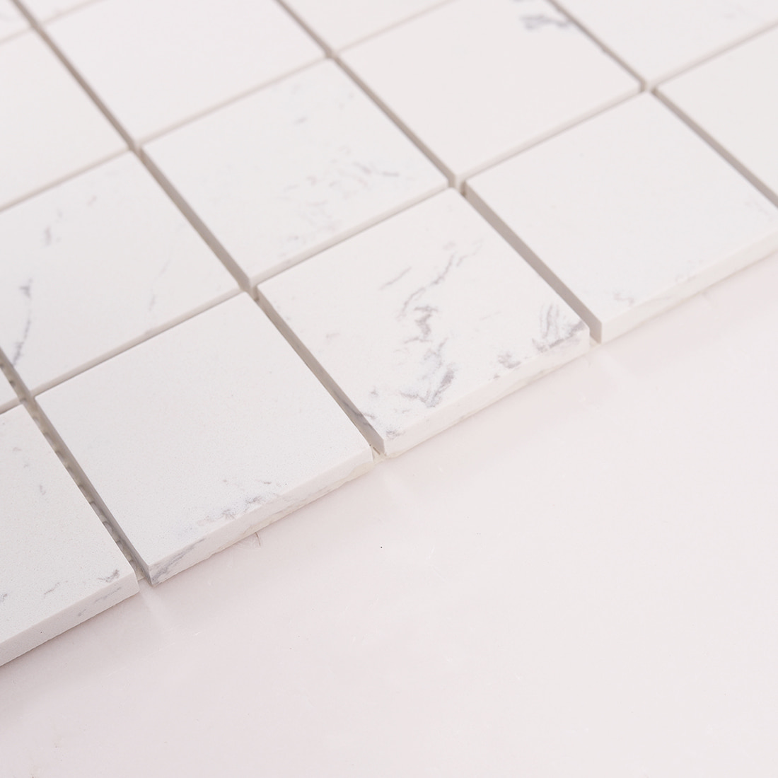 Side angle view showing thickness of white marble square mosaic tiles