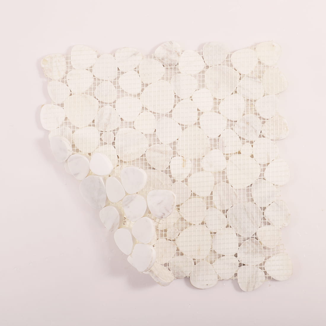 Back view of white pebble mosaic tile sheet showing mesh backing