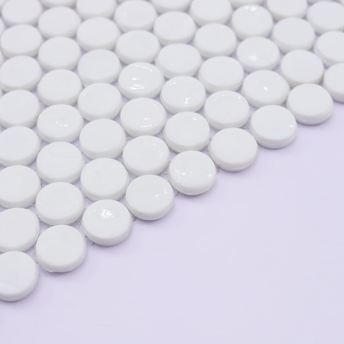 Detail of white round penny tile mosaic edge and mesh backing