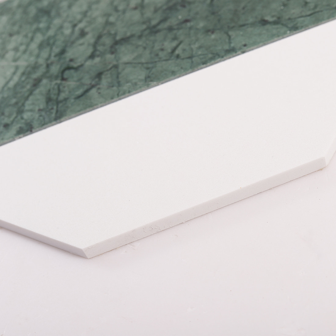 Close up of white tile edge showing thickness and smooth surface