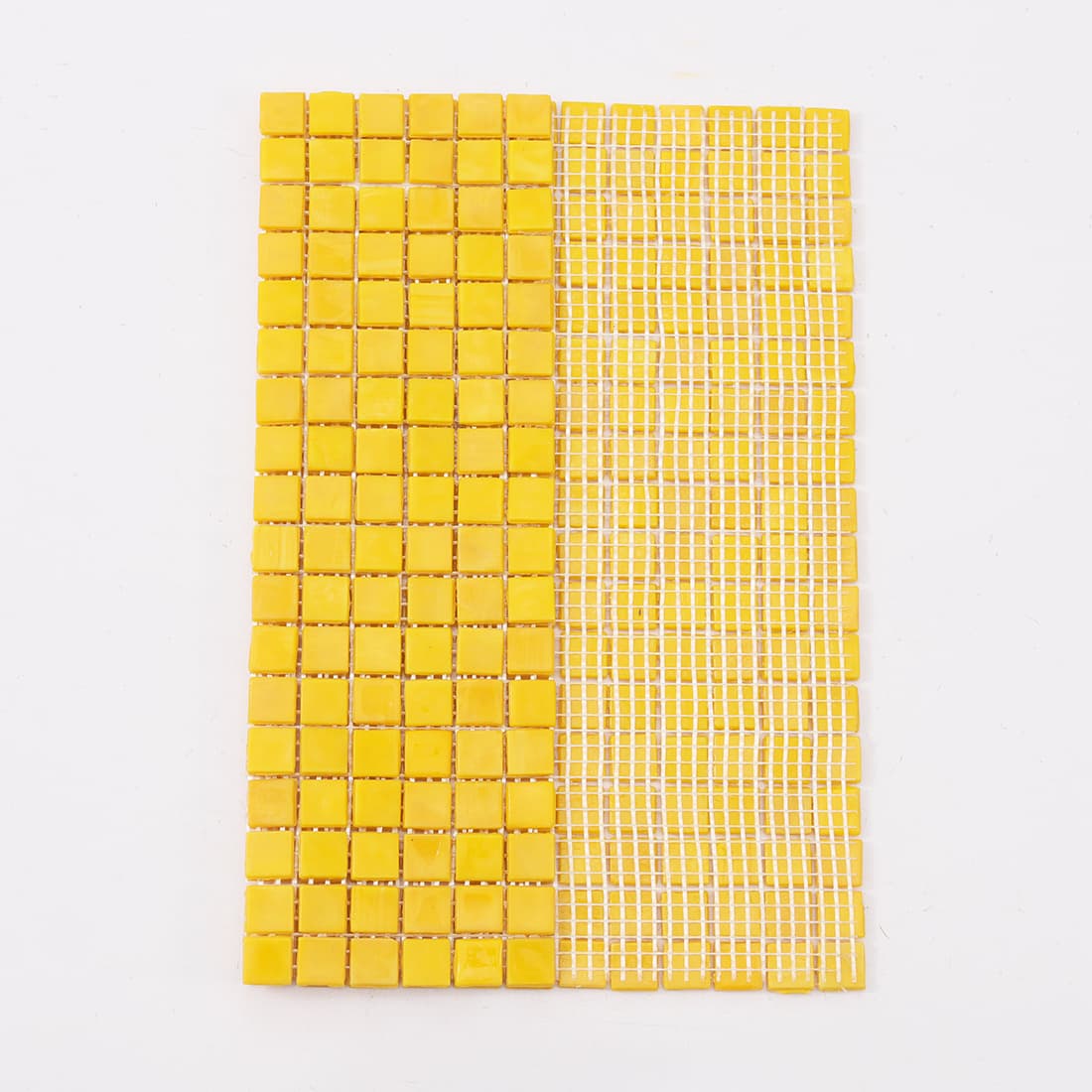 View of yellow glass mosaic tile sheet with exposed white mesh backing