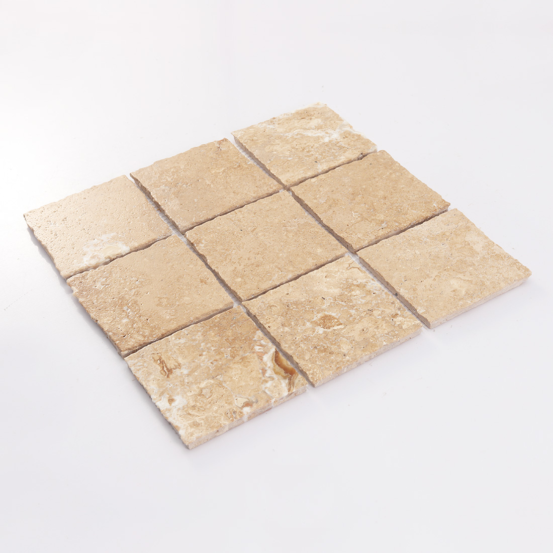 Angled view of beige square limestone mosaic tiles with natural variation
