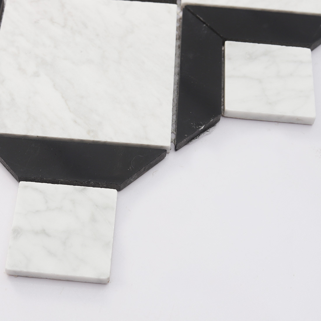 Angled edge detail of black and white marble geometric tile with visible thickness