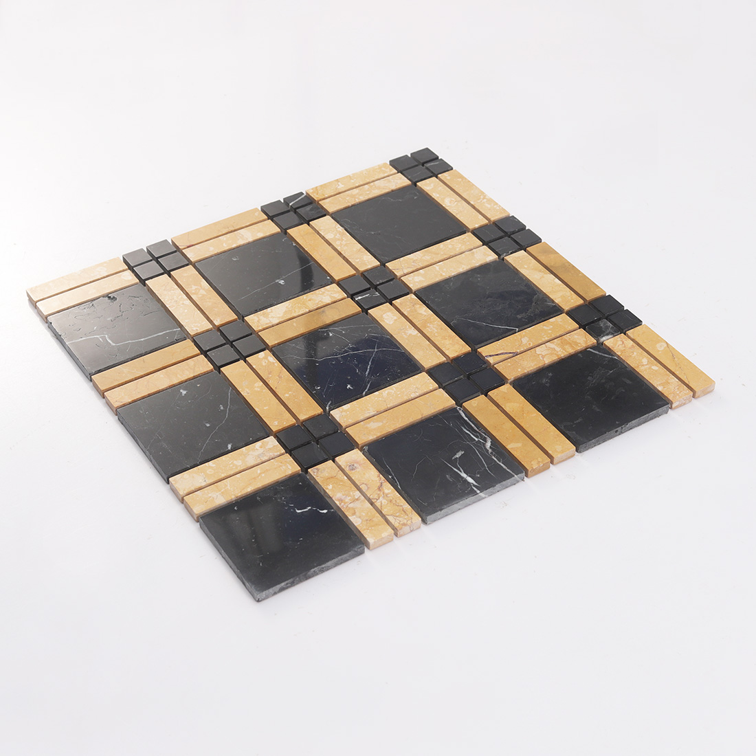 Angled view of black and yellow marble mosaic tile sheet with framed squares