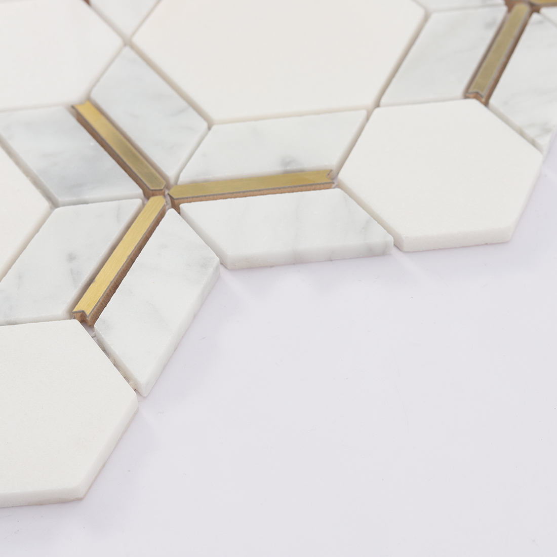 Angled view of framed hexagon marble tile with brass inlay