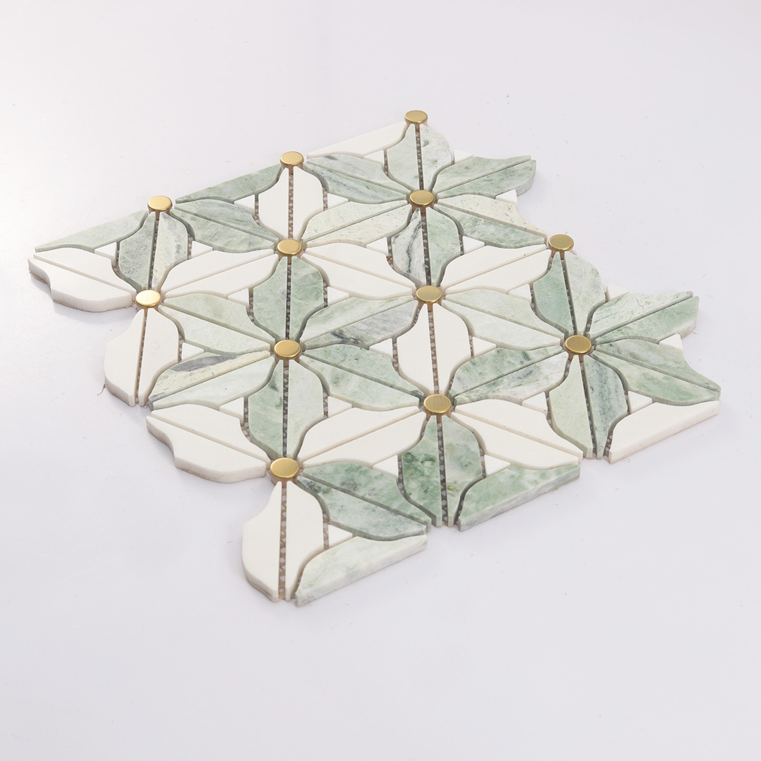 Angled view of green white flower marble mosaic with gold metal dots