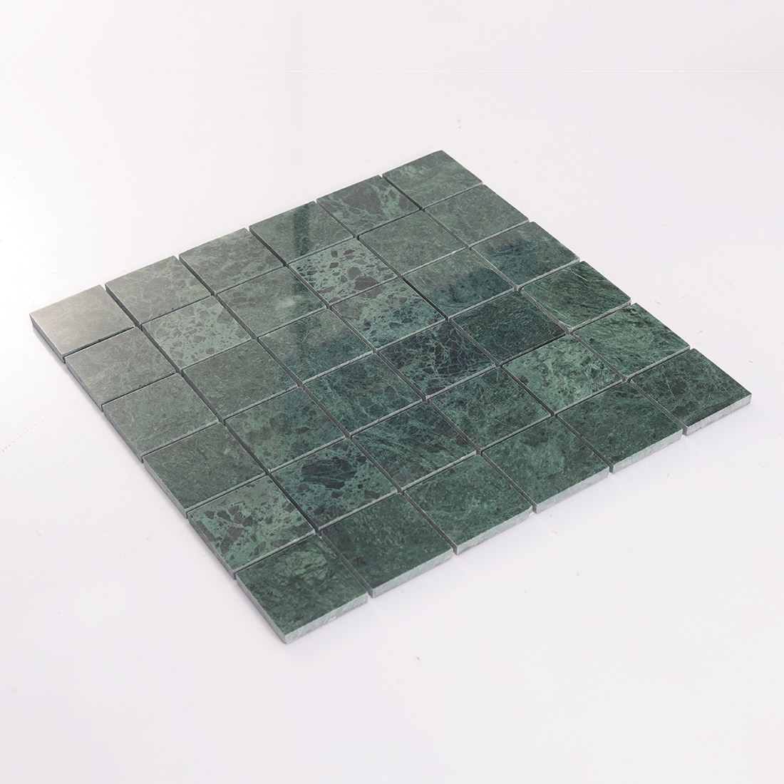Angled view of large green square marble mosaic tile with raised stone chips