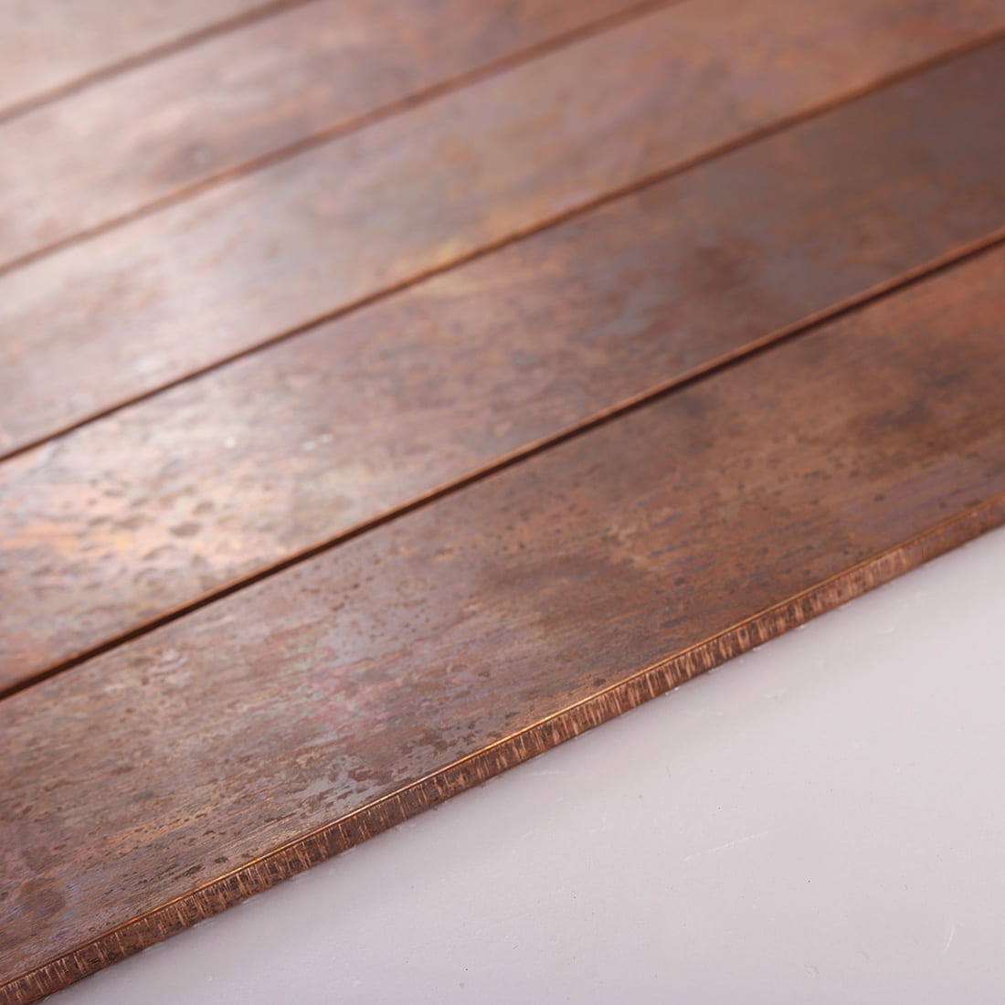 Angled view of oxidized copper long metal tile with slim edge detail