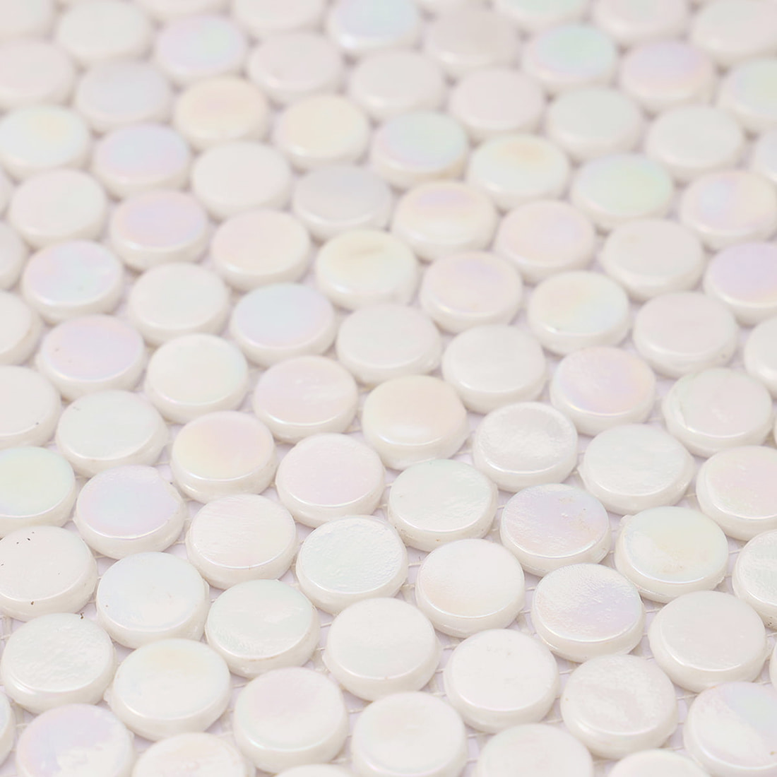 A perspective view highlighting the smooth and glossy surface of iridescent white penny tiles.